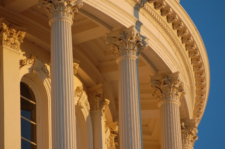 Detail of the California State Capitol at dusk. Corinthian style columns upholding the historic rotunda.